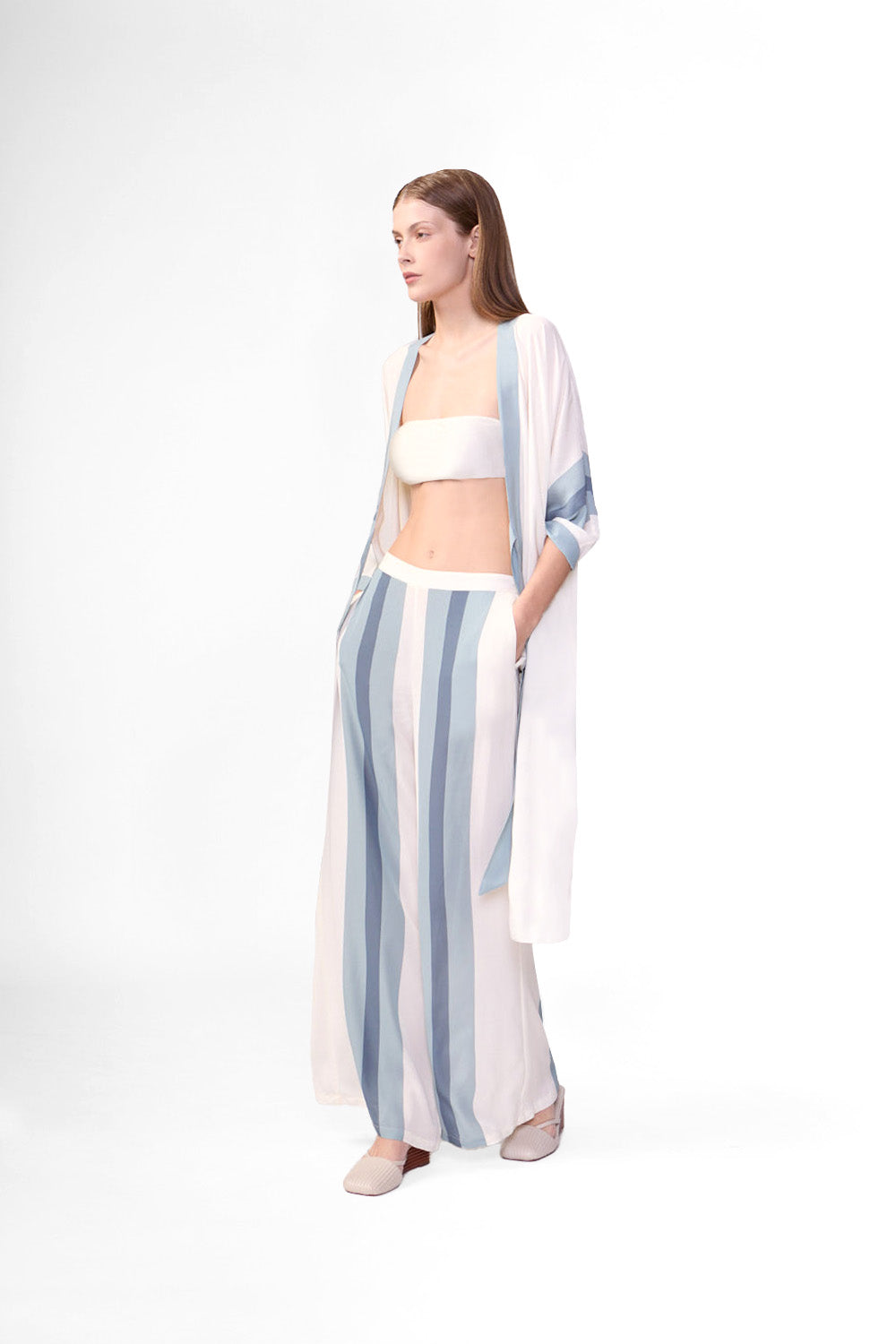 Model wearing the Bold Stripes Wide-Leg Pants color off white and light blue color, made with 100% viscose, styled for resortwear look