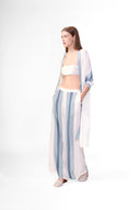 Model wearing the Bold Stripes Wide-Leg Pants color off white and light blue color, made with 100% viscose, styled for resortwear look