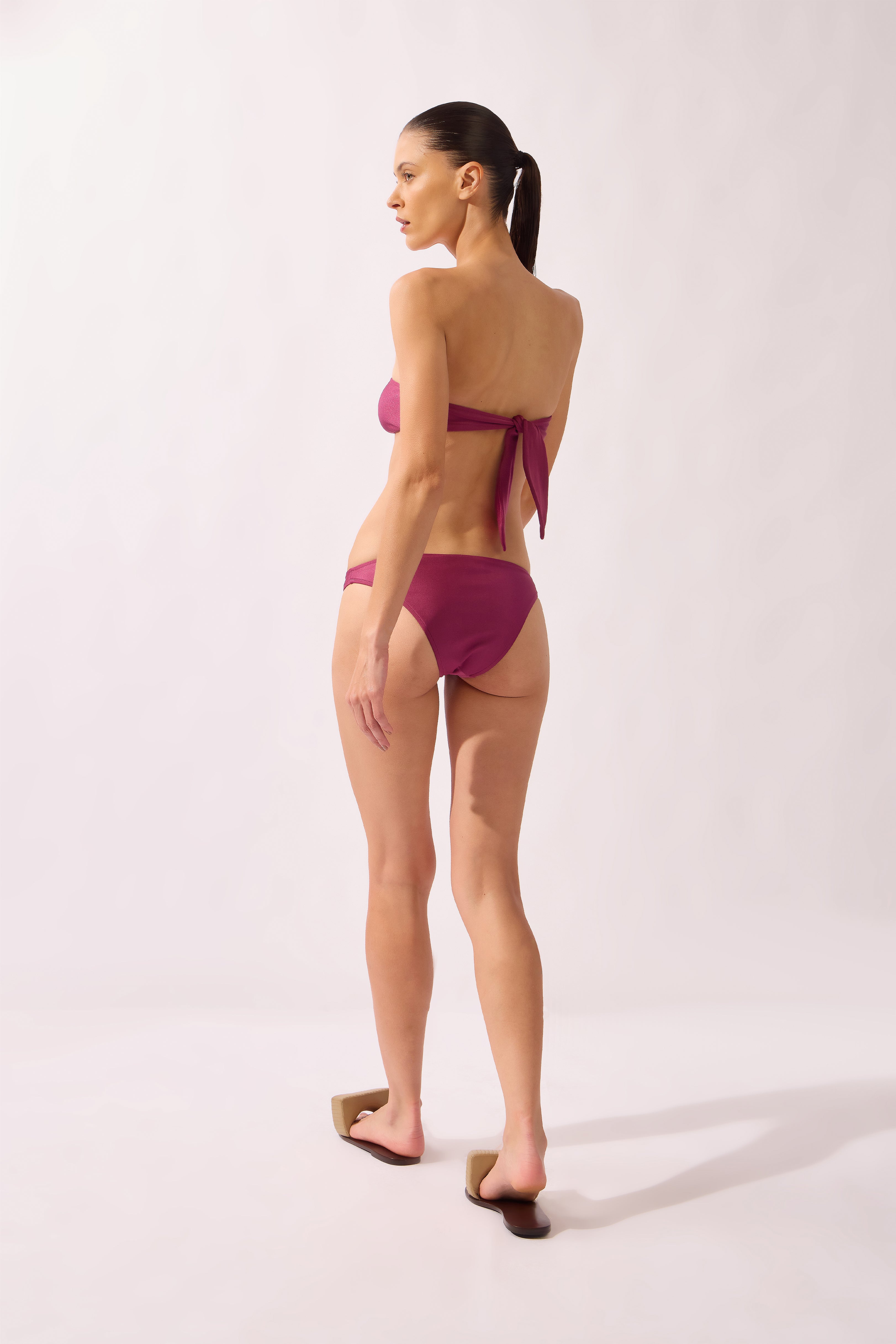 Model wearing the Flower Appliqué Bikini back color fuchsia, made from 85% polyamide 15% elastane, styled for a beachwear look