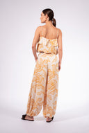 Model wearing the Foliage Crop Top back color cashew yellow, made from 10% viscose, styled for a resort look