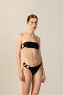 Model wearing the Geometric Bandeau Bikini black front from the HS25 with 85% Polyamide 15% Elastane styled for a beach look.   