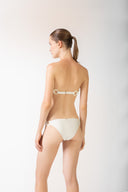Model wearing the Geometric Bandeau Bikini off white back from the HS25 with 85% Polyamide 15% Elastane styled for a beach look.   