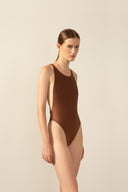 Model wearing the Geometric Cross-Back Swimsuit cappuccino front from the HS25 with 85% Polyamide 15% Elastane styled for a beach look.   