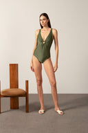 Model wearing the Geometric Cross Back Swimsuit croco green front styled for a beach look