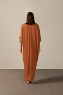 Model wearing the Geometric Long Kaftan cognac back from the HS25 with 100% viscose styled for a drinks by the pool look.   