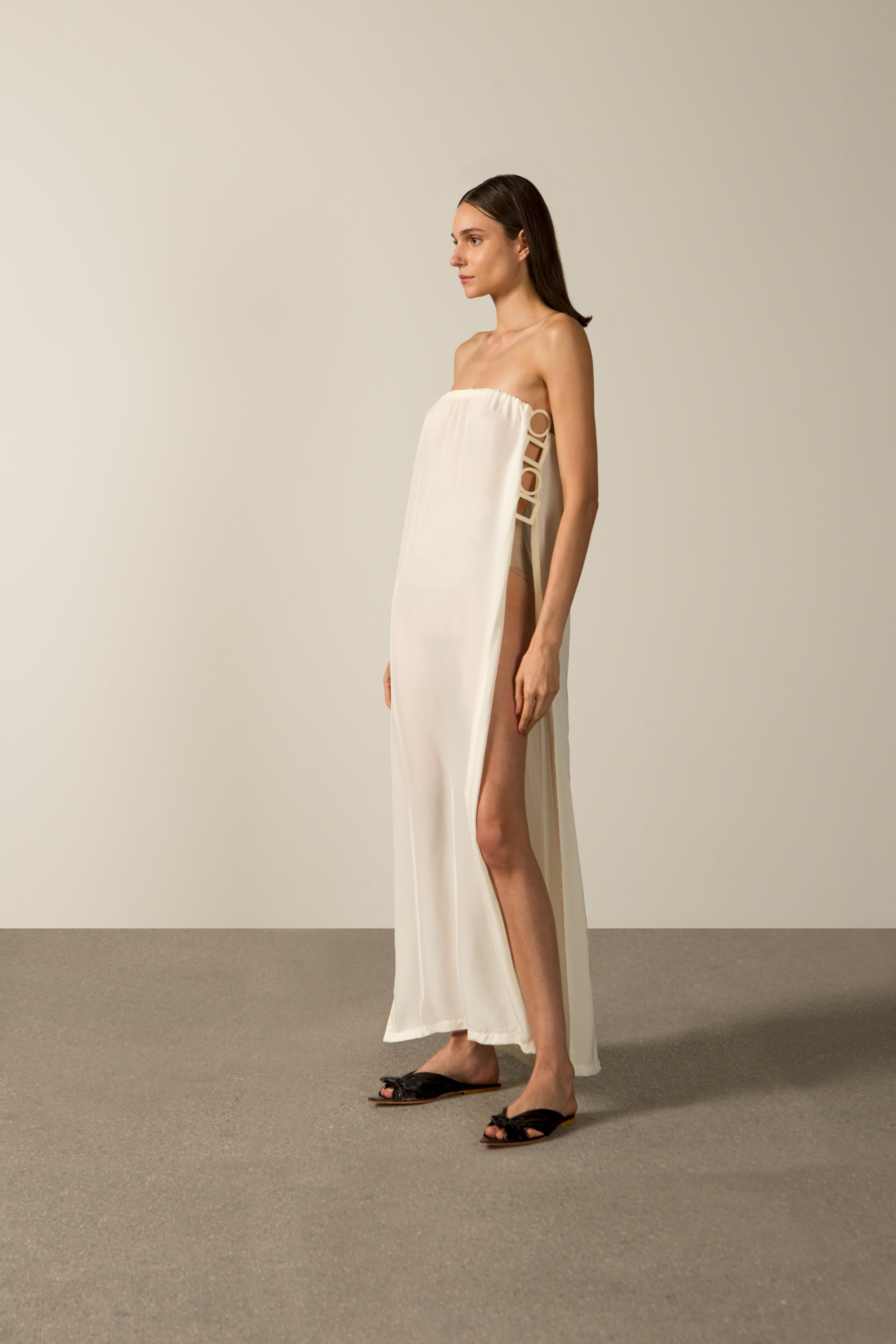 Model wearing the Geometric Strapless Long Dress color off white made with 100% viscose, styled for an after the beach look