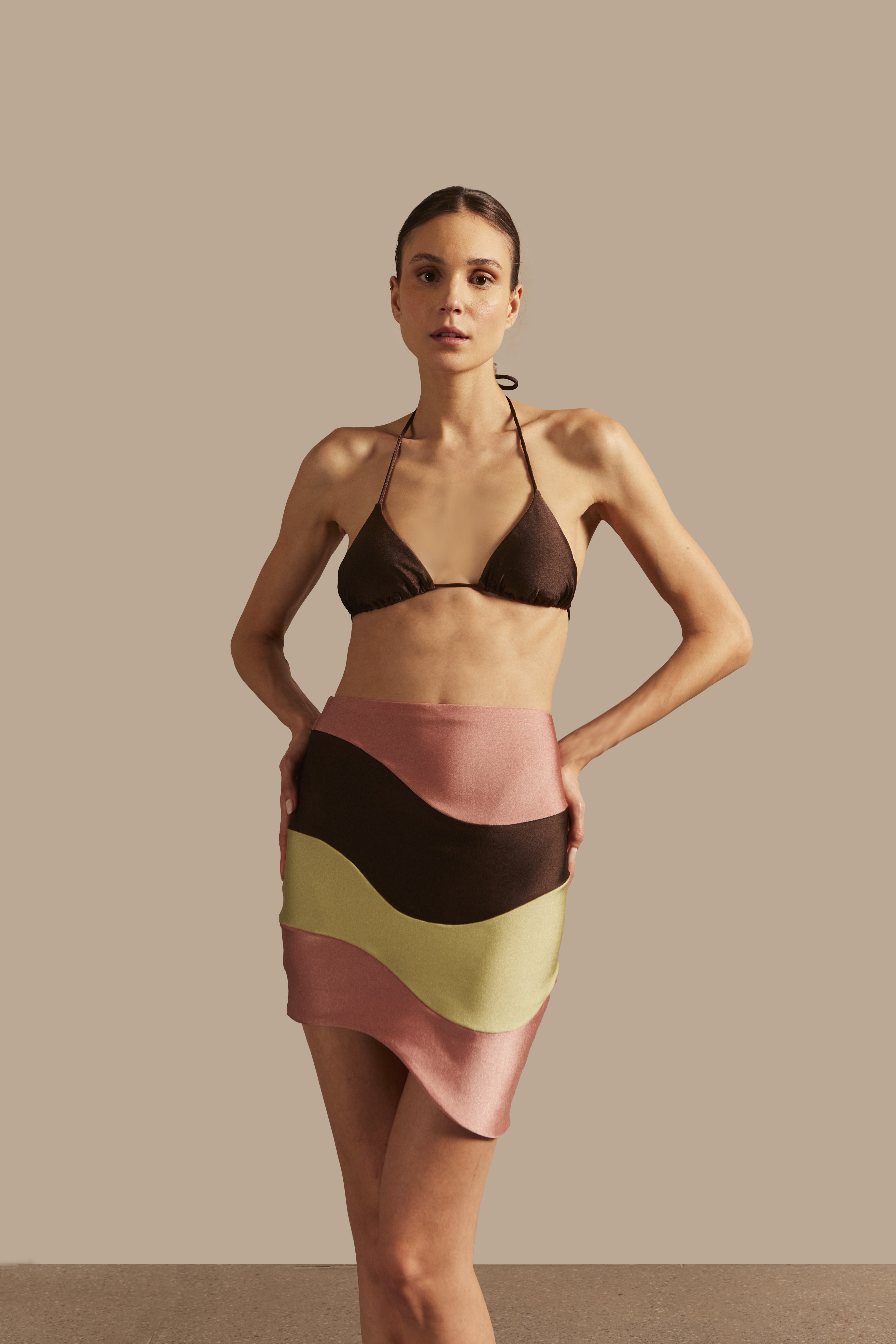 Model wearing the Giardino Mini Skirt Front showcasing its Coffee/Green/Pink color on 85% Polyamide 15% Elastane fabric.  
