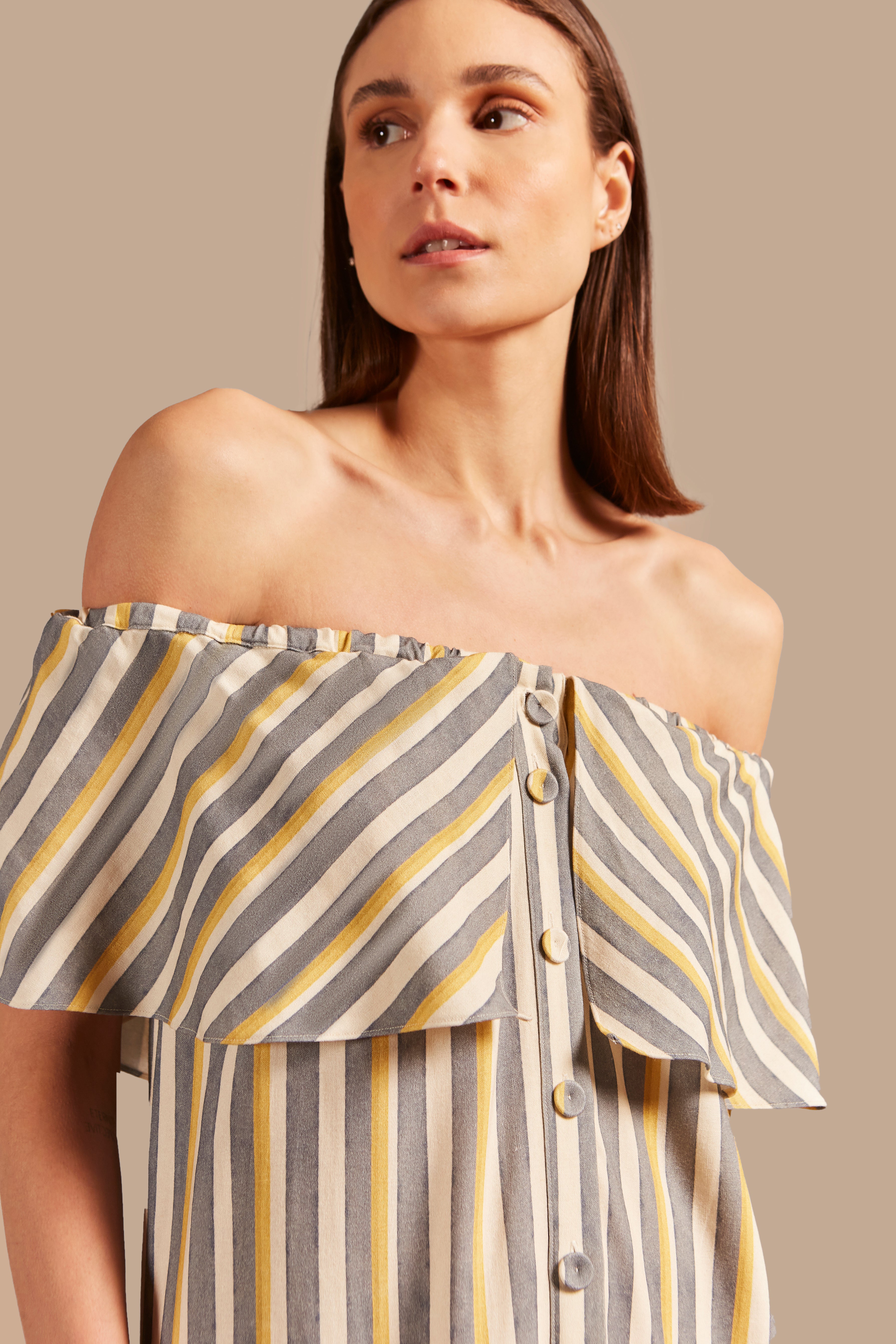 Model wearing the  Golden Age Off-The-Shoulder Long Dress showcasing a close up of its vintage references with off white, blue and yellow print on a modal and linen fabric.