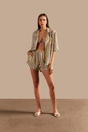 Model wearing the Golden Age Short Shorts Front showcasing its unique  print with elastic waistband on 70% Modal 30% Linen fabric, styled for a beachwear look.