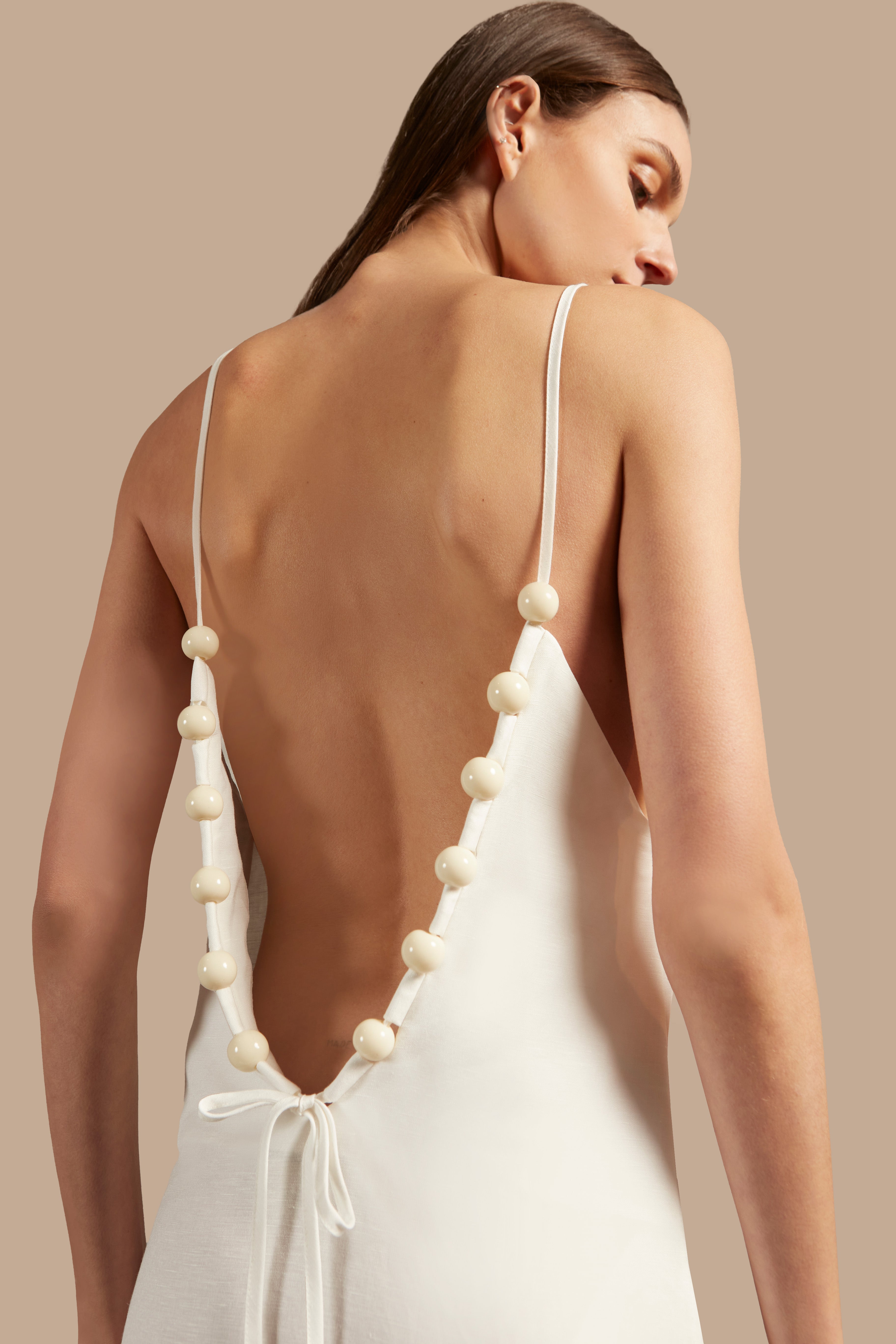 Close-up of the Golden Age Solid Straps Long Dress in off-white, showcasing its thin straps and fluid fabric.