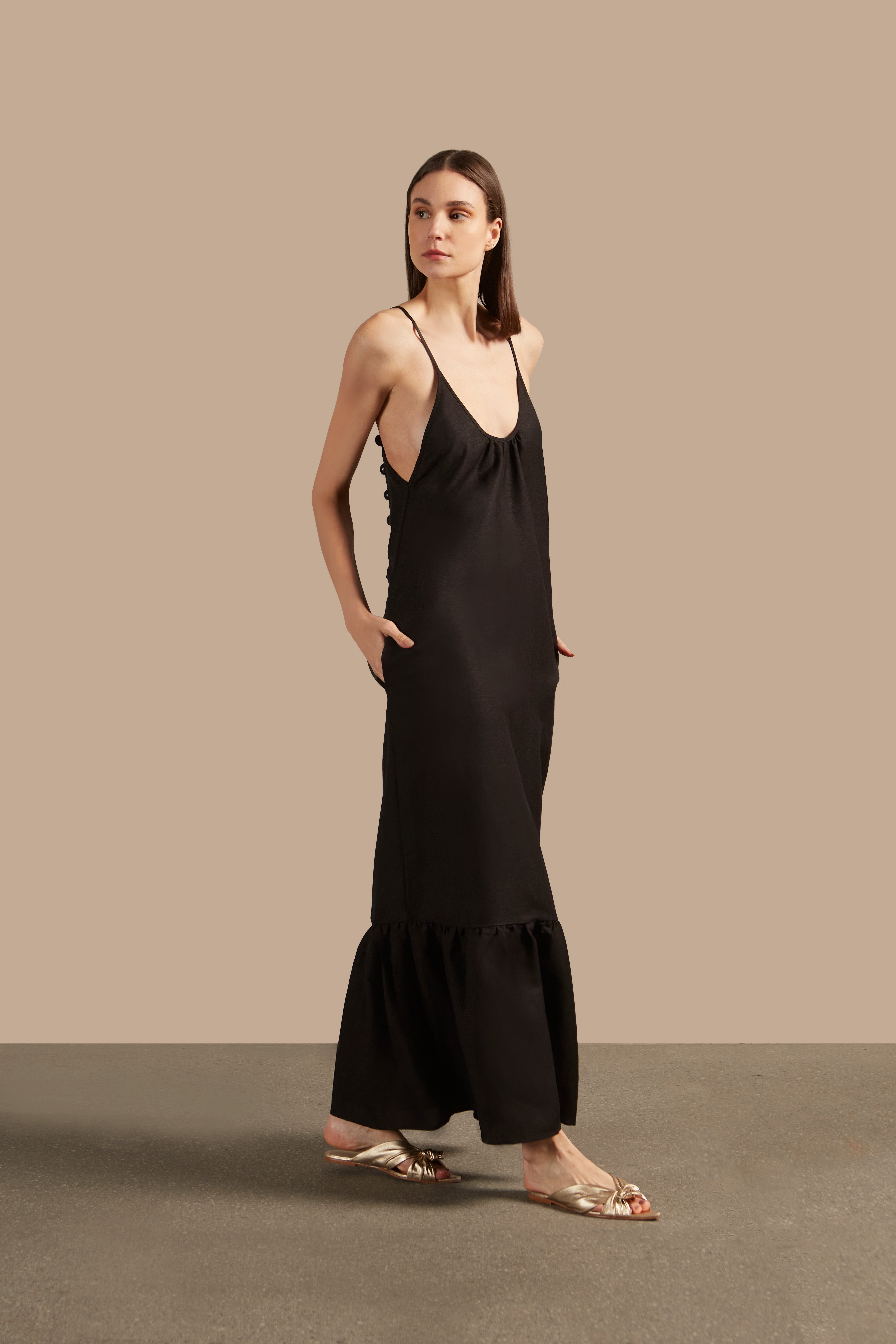 Side view of the Golden Age Solid Straps Long Dress in black, showcasing its flowing design and sophisticated neckline.