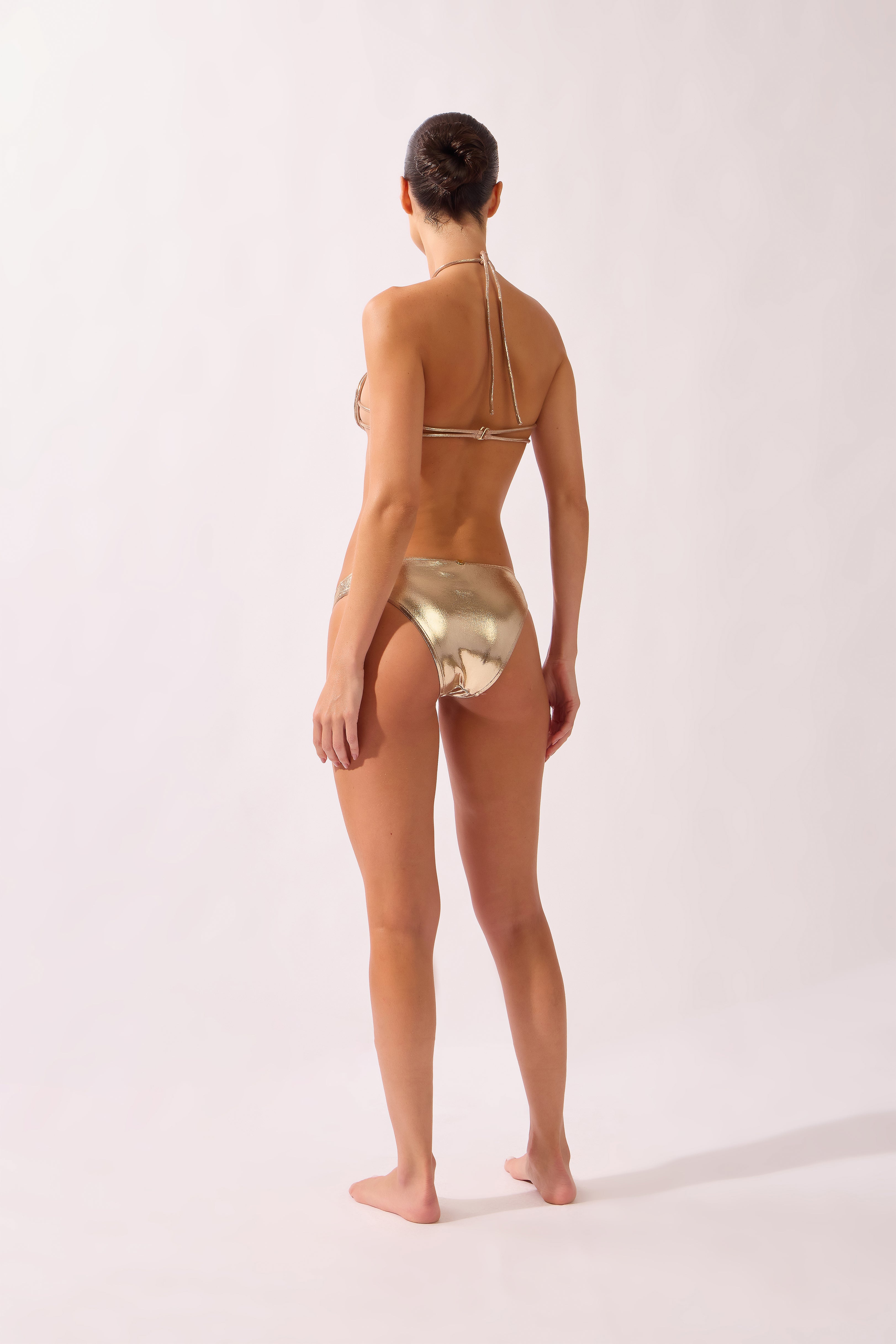 Model wearing the Golden Spiral Bikini back color golden, made from 92% polyester 08% elastane, styled for a beachwear look