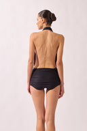 Model wearing the Halterneck Swimsuit back color black, made from 86% polyamide 14% elastane, styled for a beachwear look