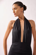 Model wearing the Halterneck Swimsuit detail color black, made from 86% polyamide 14% elastane, styled for a beachwear look