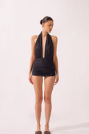 Model wearing the Halterneck Swimsuit front color black, made from 86% polyamide 14% elastane, styled for a beachwear look