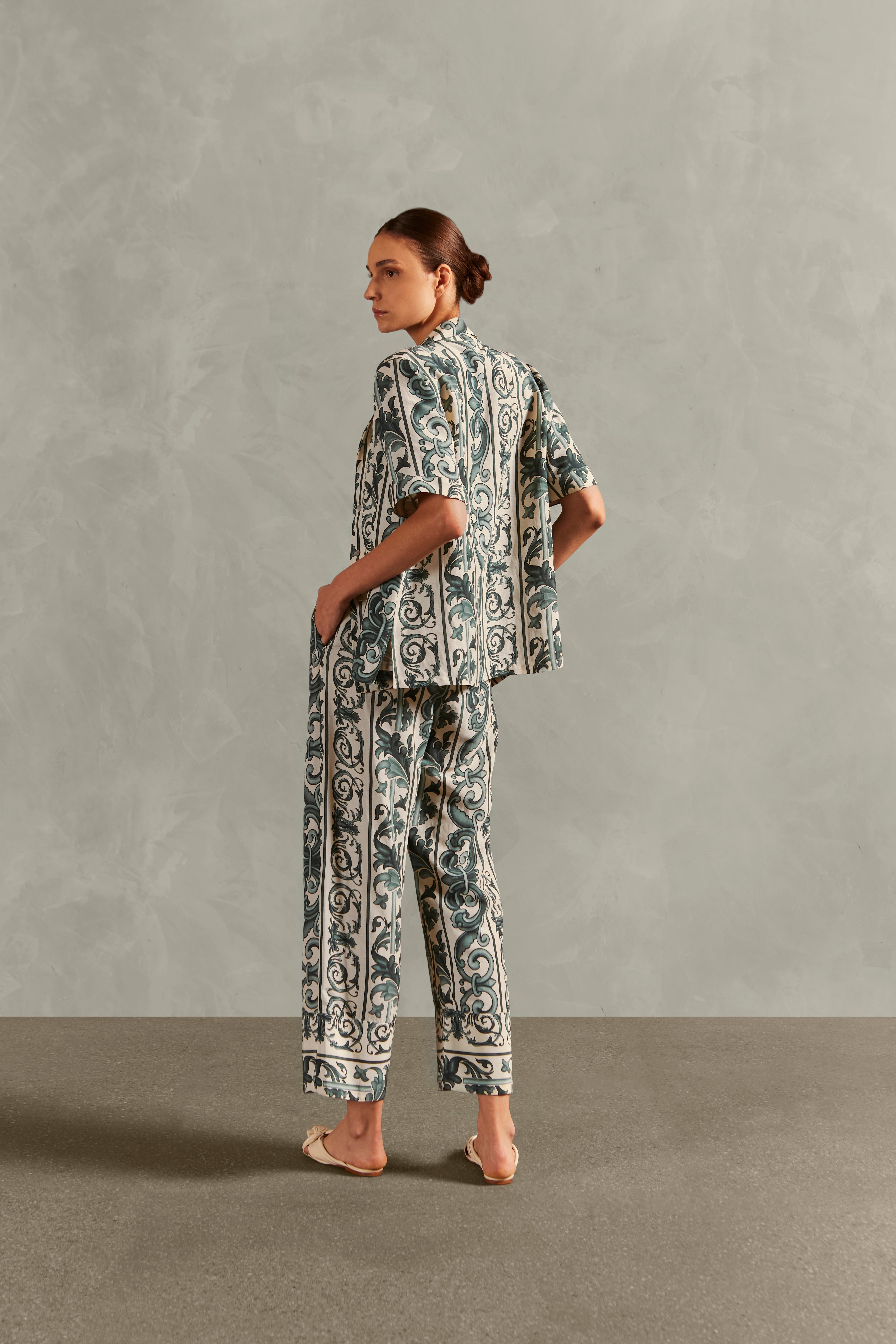 Model wearing the Hera Straight Pants Back showcasing its vintage references with Blue print on 56% Viscose 24% Linen 20% Silk fabric, styled for a resort look.