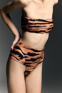 Model wearing the High-Leg Strapless Bikini detail from the Adriana Degreas and Sabine Getty collab with 75% Polyamide 25% Elastane styled for a beachwear look. 