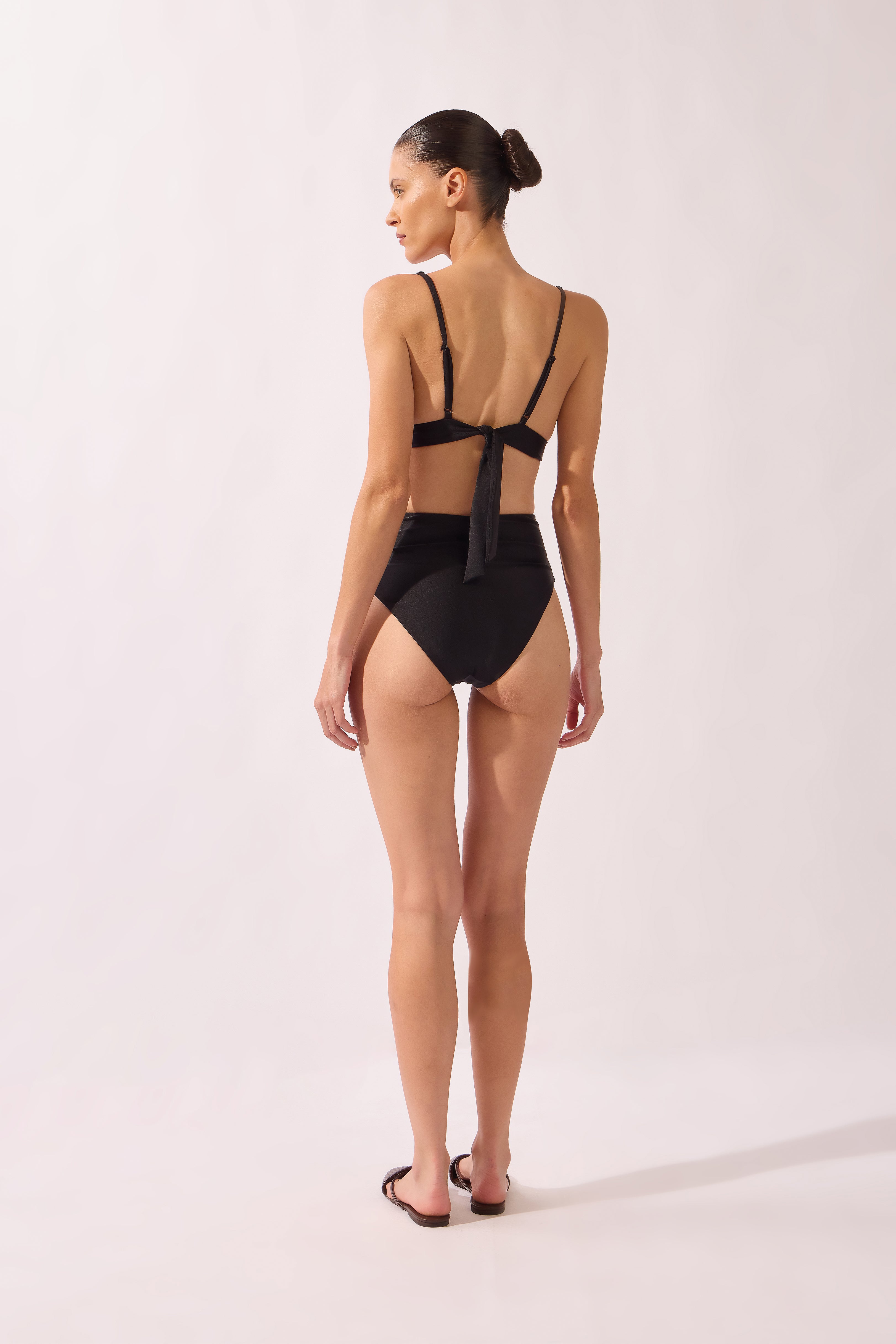 Model wearing the High-Leg Belted Bikini back color black, made from 85% polyamide 15% elastane, styled for a beachwear look