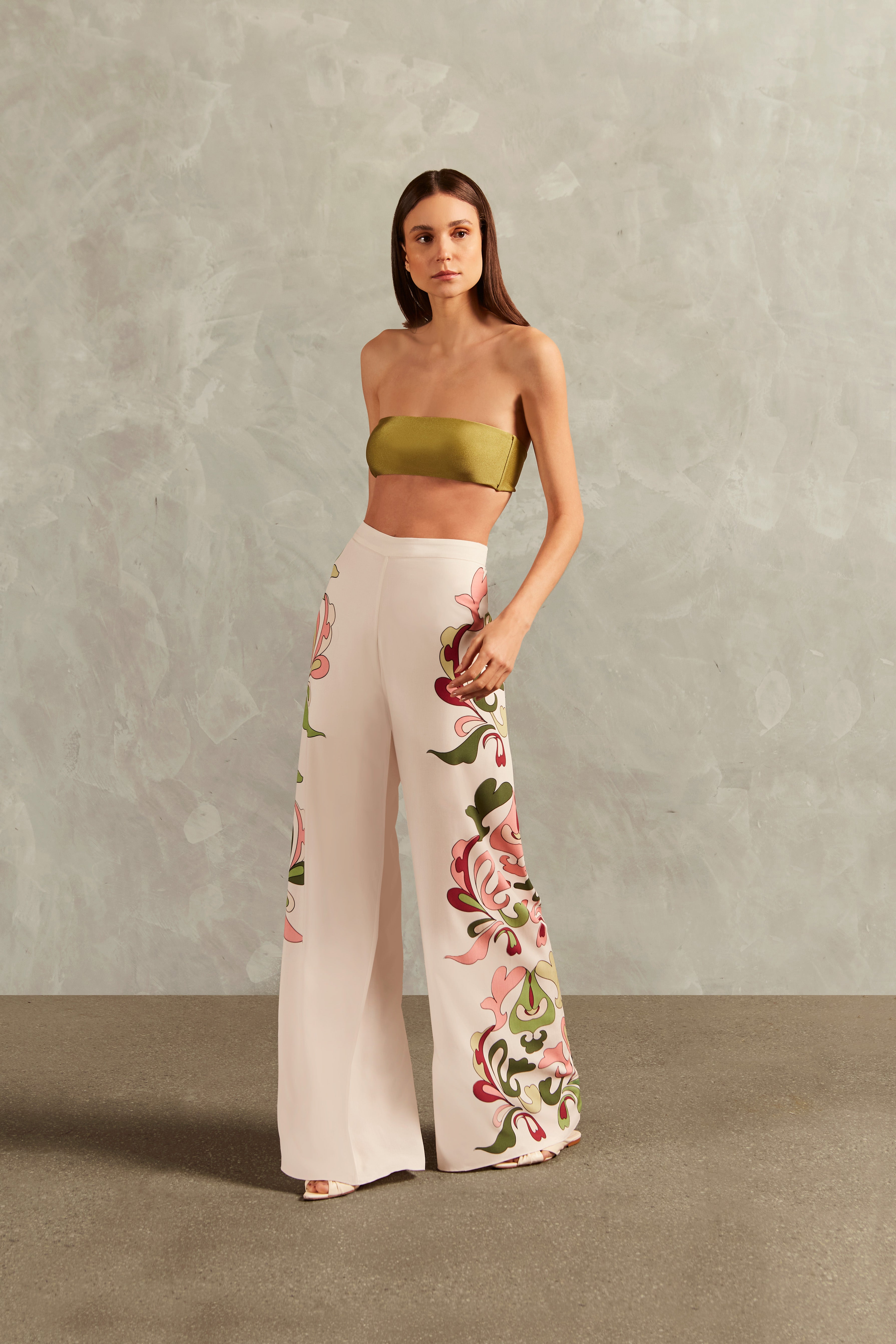 Model wearing the Inamorata Wide-Leg Pants Front showcasing its Off White color on 100% Viscose fabric, styled for an post-beach look. 