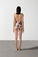 Model wearing the Inamorata Ruched Swimsuit back color pink with 85% Polyamide 15% Elastane styled for a beachwear look  