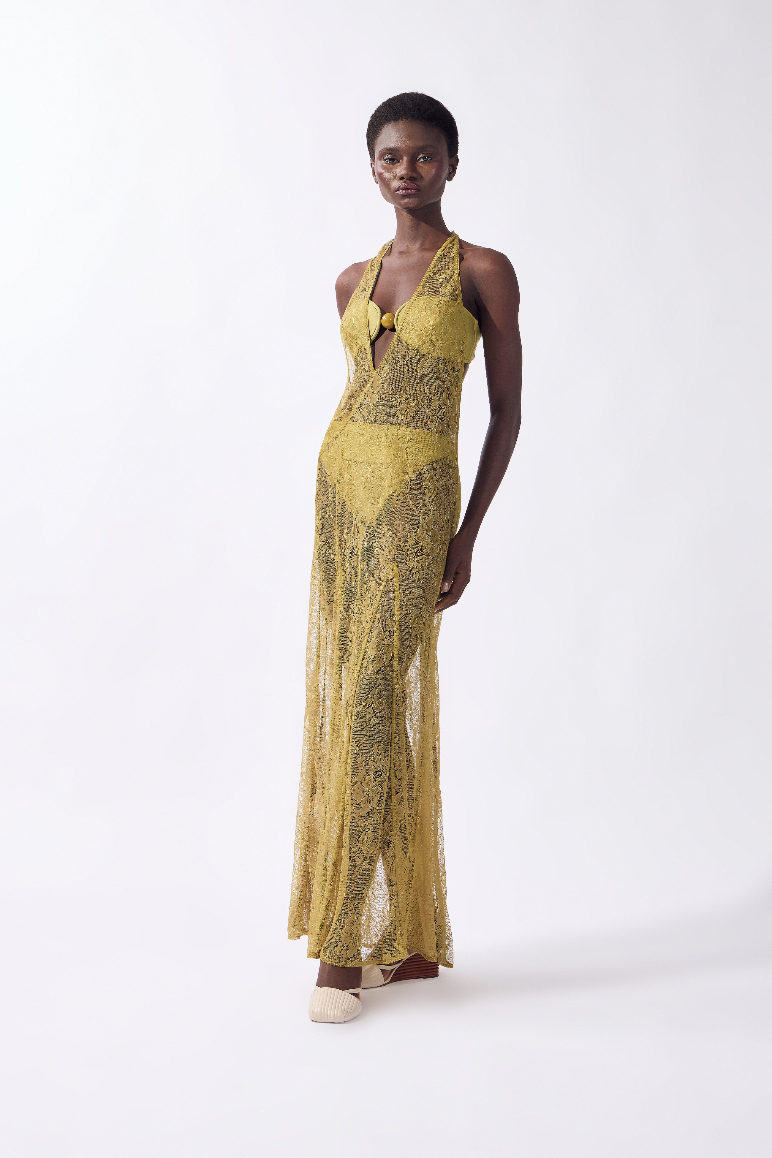 Model wearing the Lace Bare-Back Maxi Dress front color pistachio, made from 100% polyamide, styled for a post-beach look