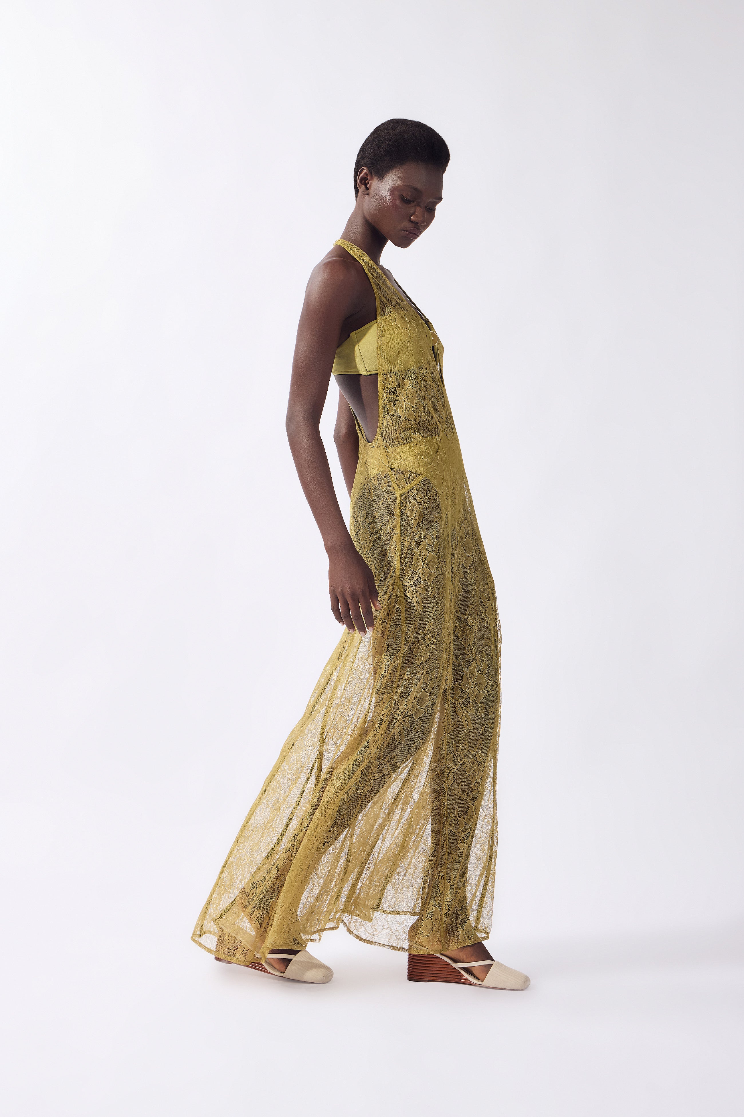 Model wearing the Lace Bare-Back Maxi Dress detail color pistachio, made from 100% polyamide, styled for a post-beach look