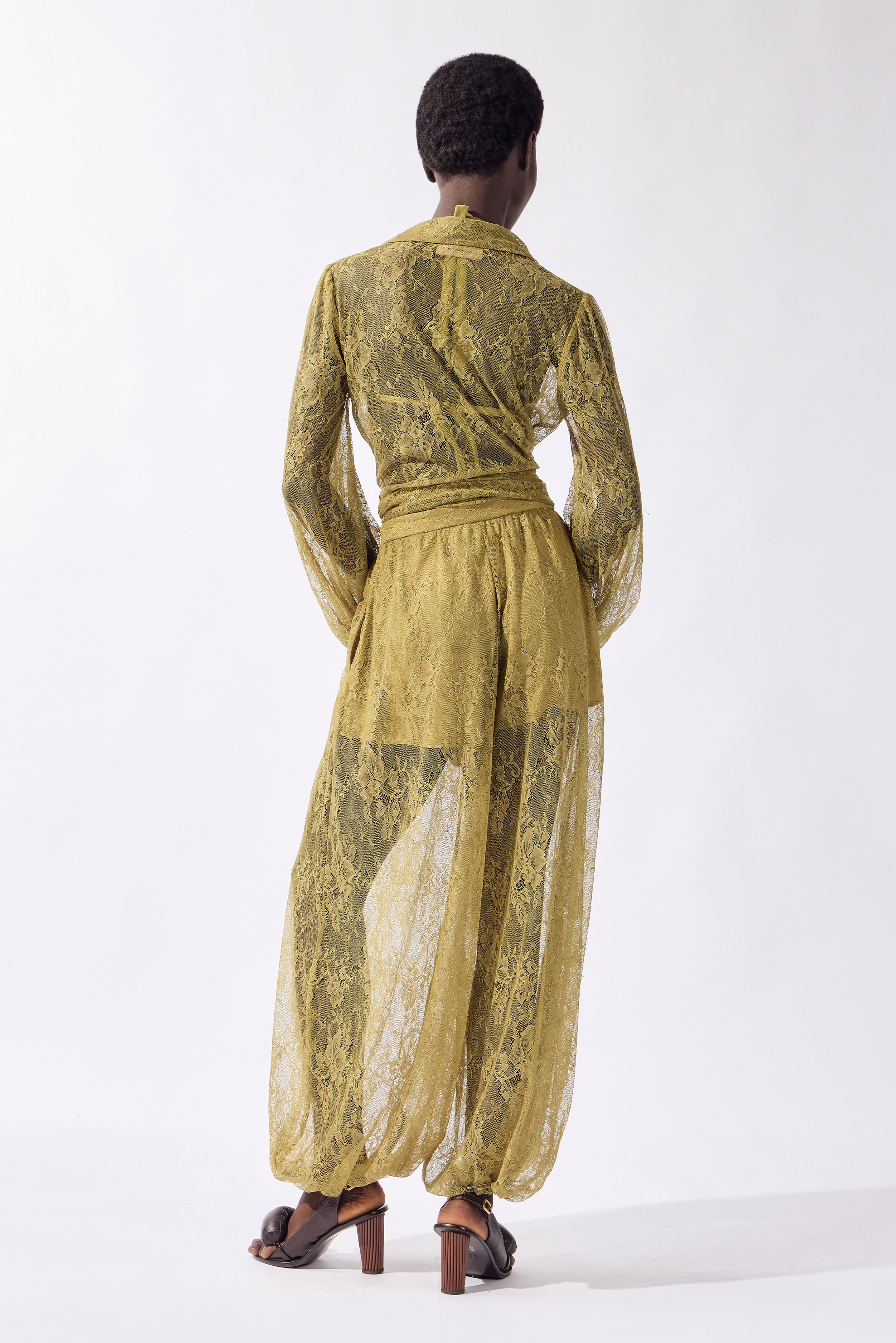 Model wearing the Lace Bubble Pants back, color pistachio, made from 100% polyamide, styled for a resort look