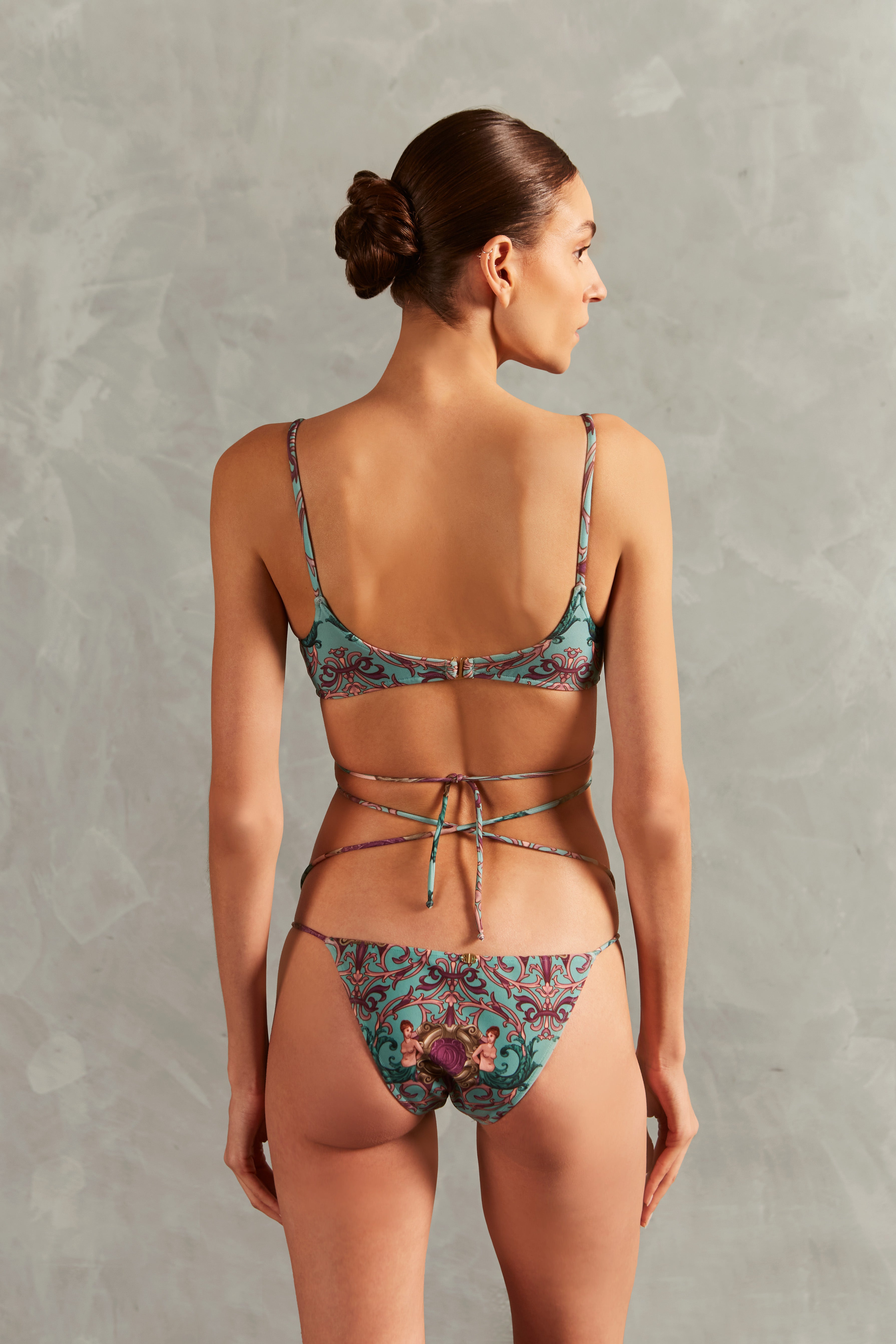 Model wearing the Le Sirenuse Wraparound Ties Bikini Back showcasing its Turquoise color on 85% polyamide 15% elastane fabric.