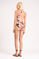 Model wearing the Lina One Shoulder Swimsuit detail back color unique, made from 85% polyester 15% elastane, styled for beachwear look 