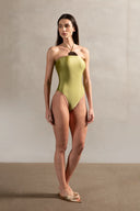Model wearing the Mobile Apliqué Green Pistachio Swimsuit Front showcasing its vintage aesthetic with green pistachio print on  85% polyamide15% spandex fabric.