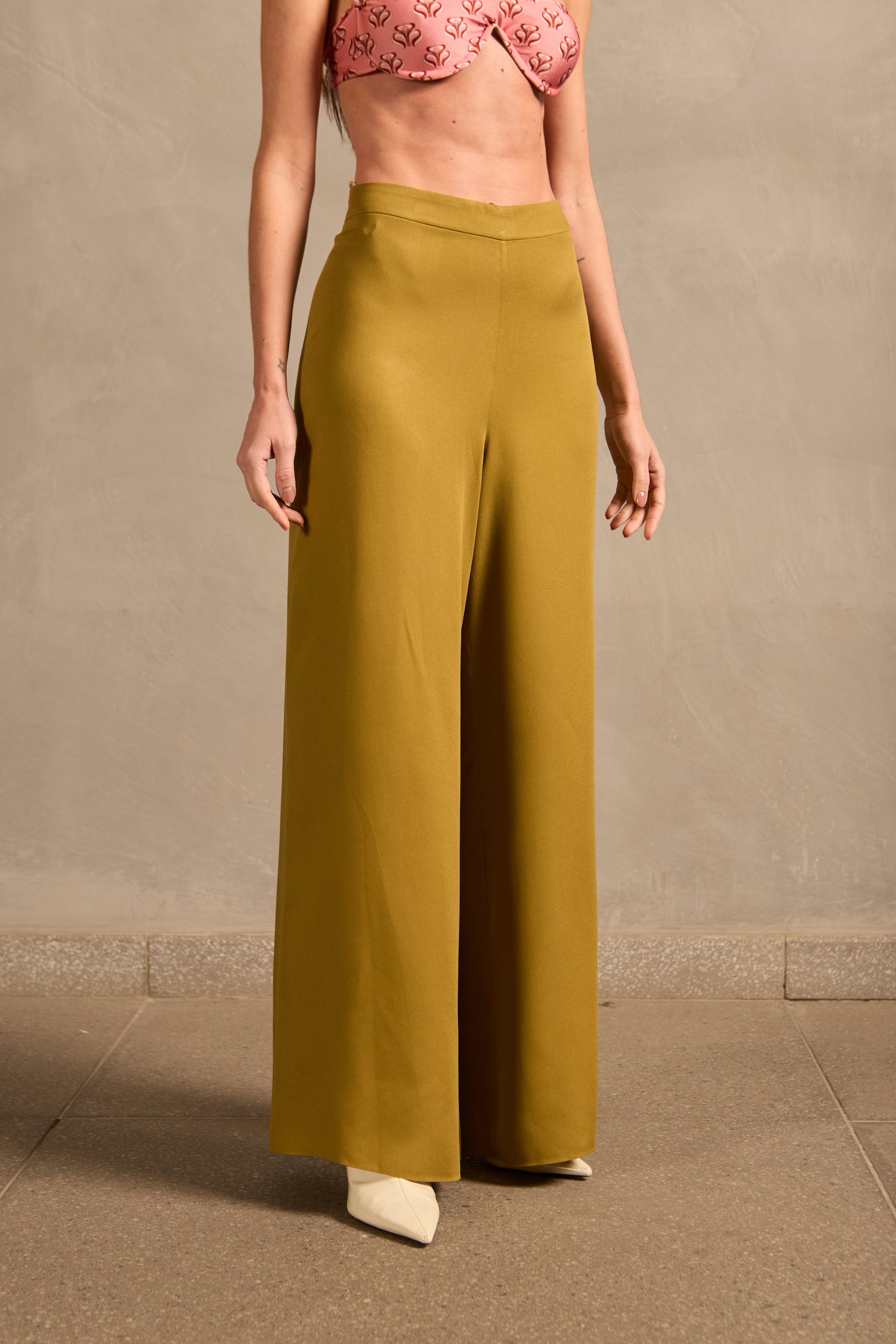 Model wearing the Mobile Wide-Leg Pants detail showcasing its 70s-inspired with light green print on off-white 100% Modal fabric.