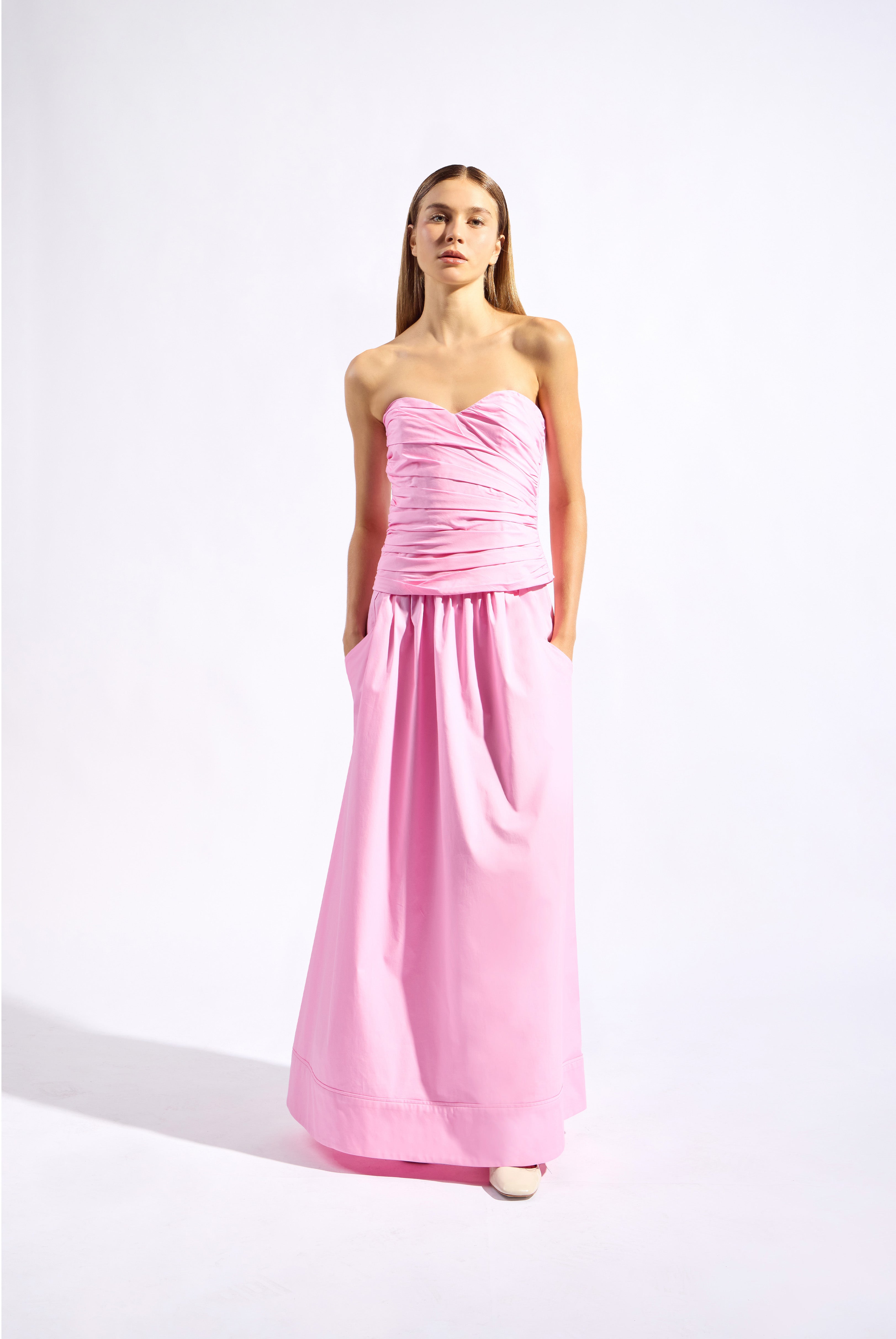 Model wearing the Opulence Strapless Top look color light pink made with 97% Cotton 3% Elastane,  styled for resortwear look 