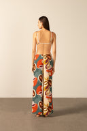 Model wearing the Organic Floral Wide-Leg Pants back with unique color styled for a beach look