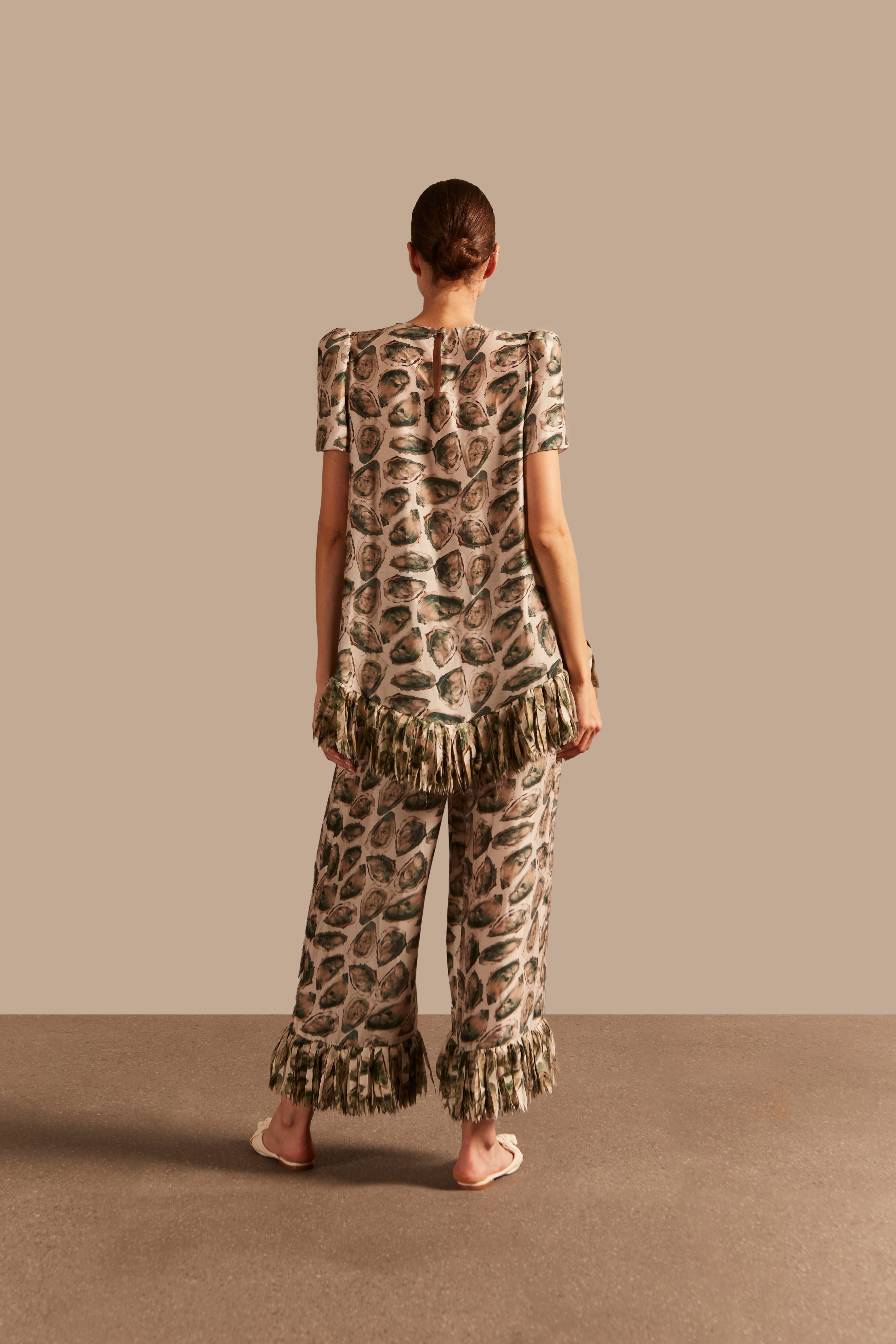 Model wearing the Oysters Fringes Pants showcasing the back of it's unique design with Oysters Print, on a viscose and silk fabric.