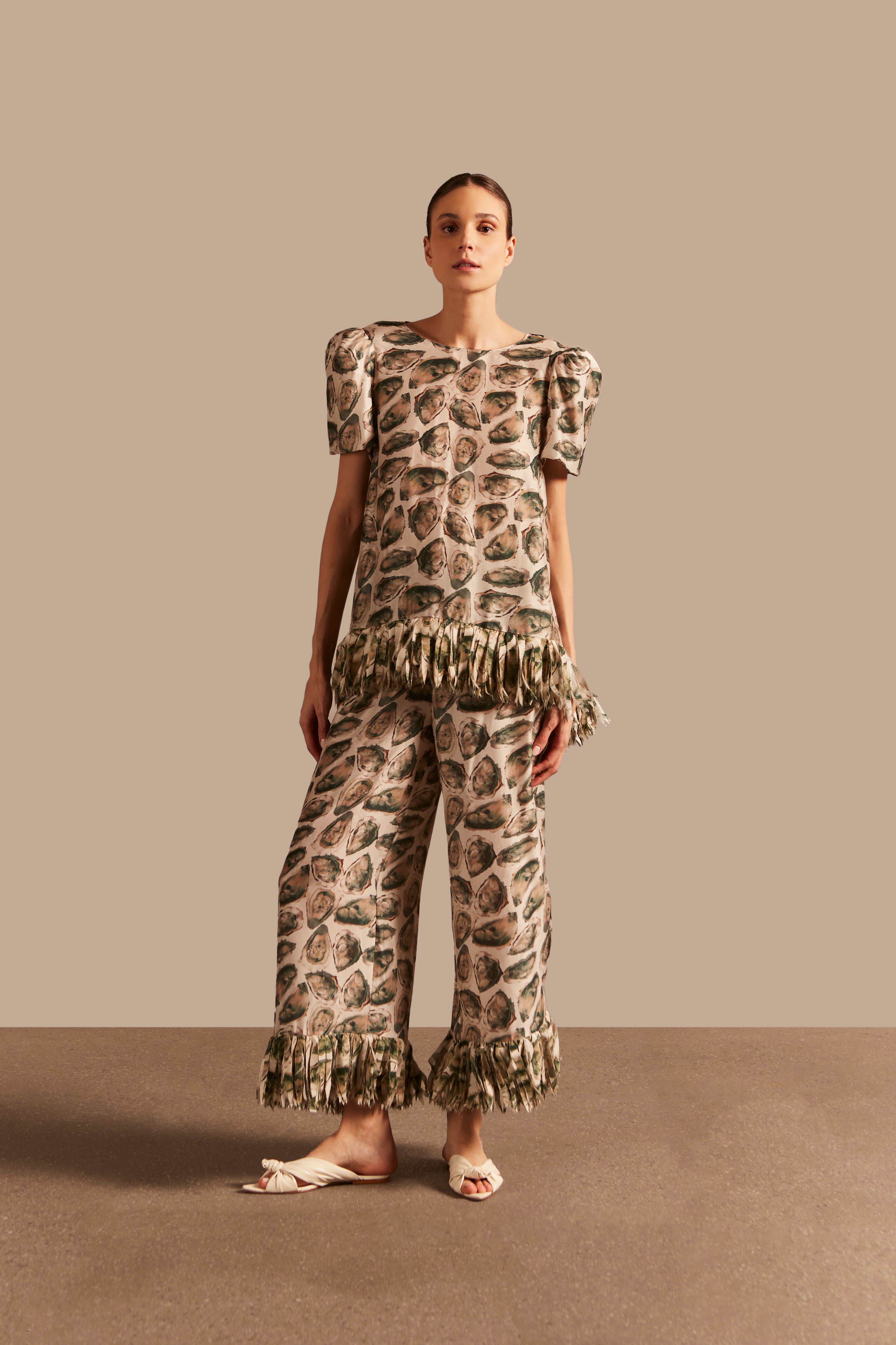 Model wearing the Oysters Fringes Pants showcasing the front of it's unique design with Oysters Print, on a viscose and silk fabric.