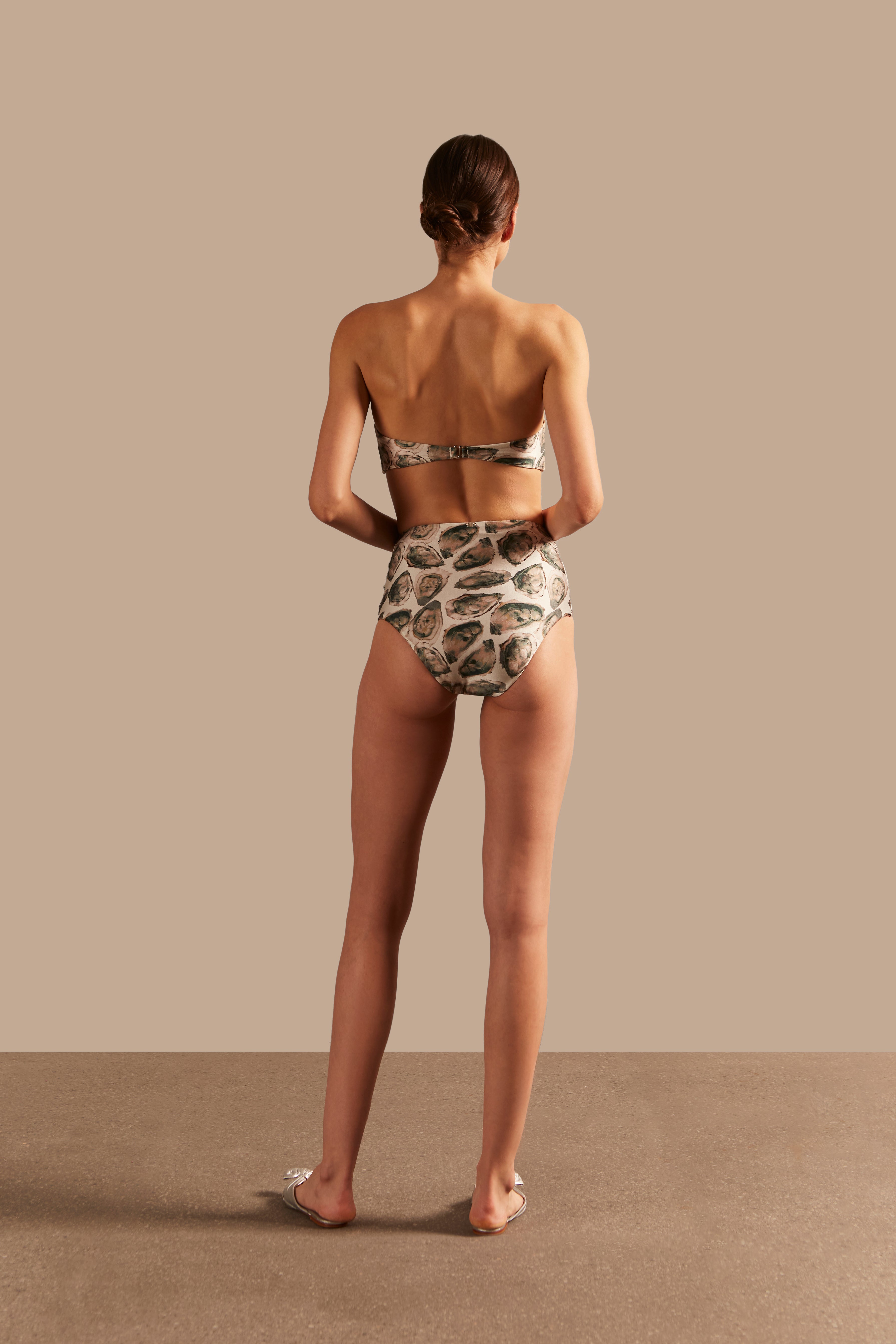 Model wearing the Oysters High-Waisted Bikini showcasing the back of it's retro inspiration, with Oysters Print, on a stretchy fabric.