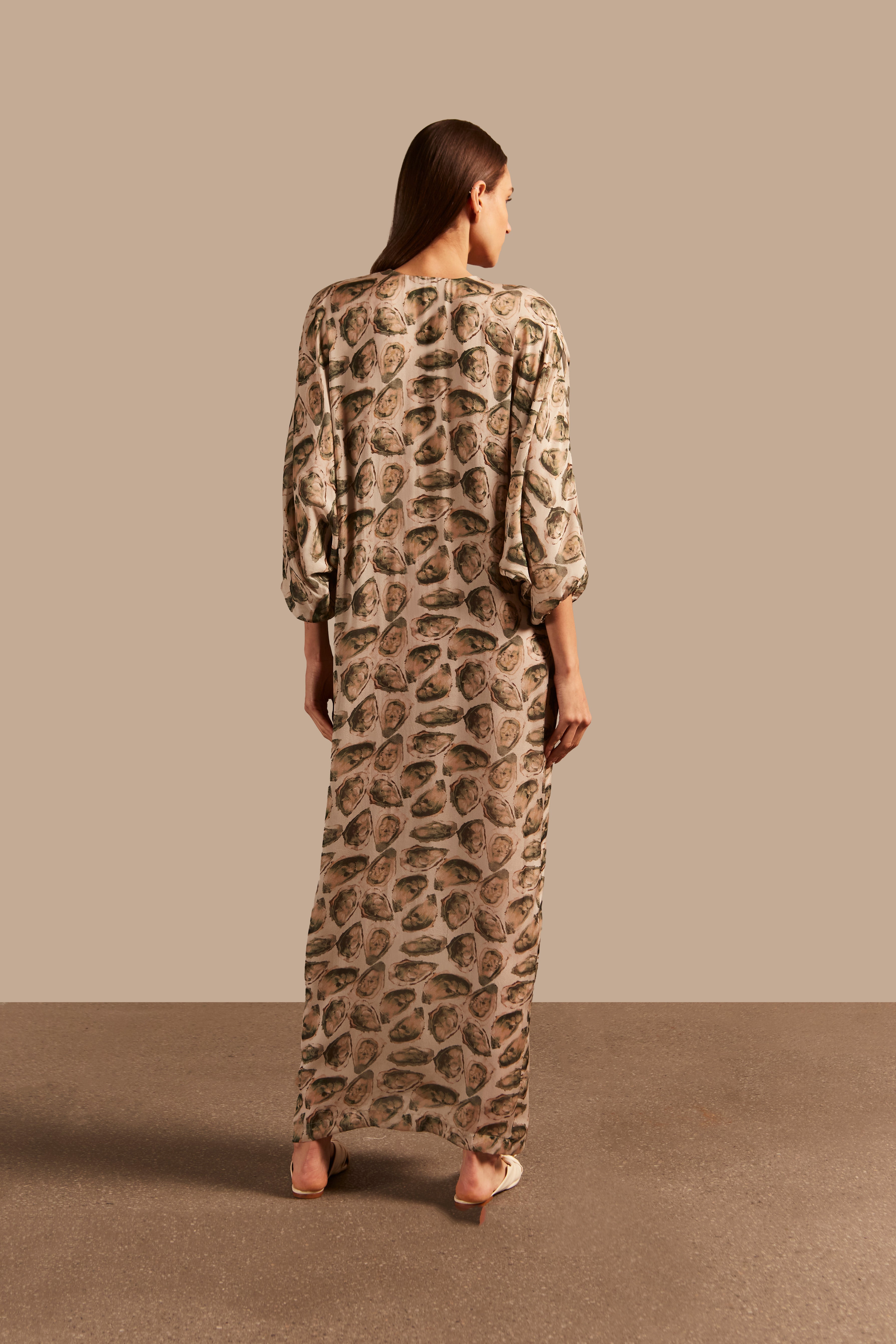 Model wearing the Oysters Long Kaftan With Knot showcasing the back of it's vintage style, with Oysters Print, on a silk fabric.