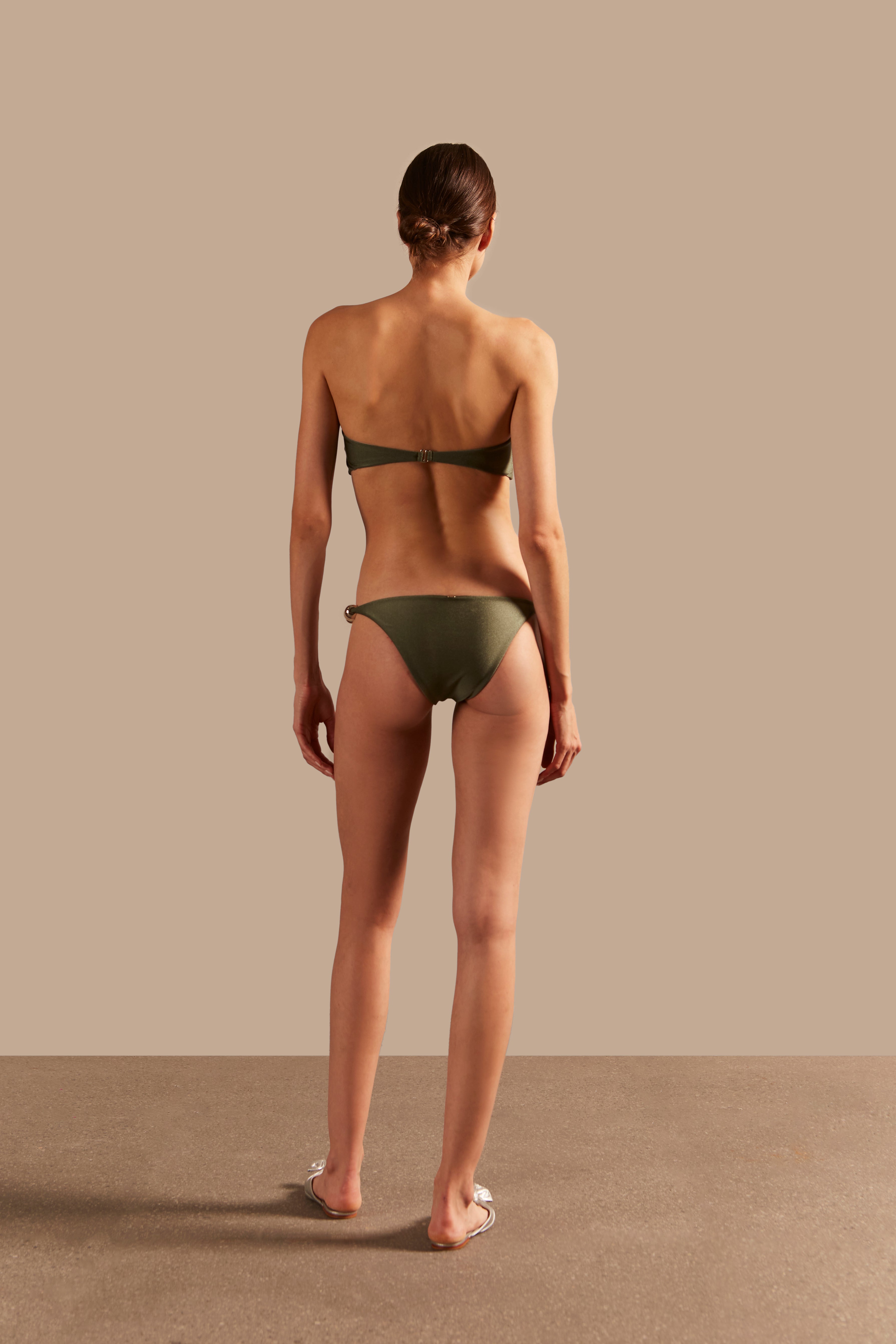 Model wearing the Oysters Solid Green Strapless Bikini With Pearl showcasing the back of it's redesigned version, on a stretchy fabric.