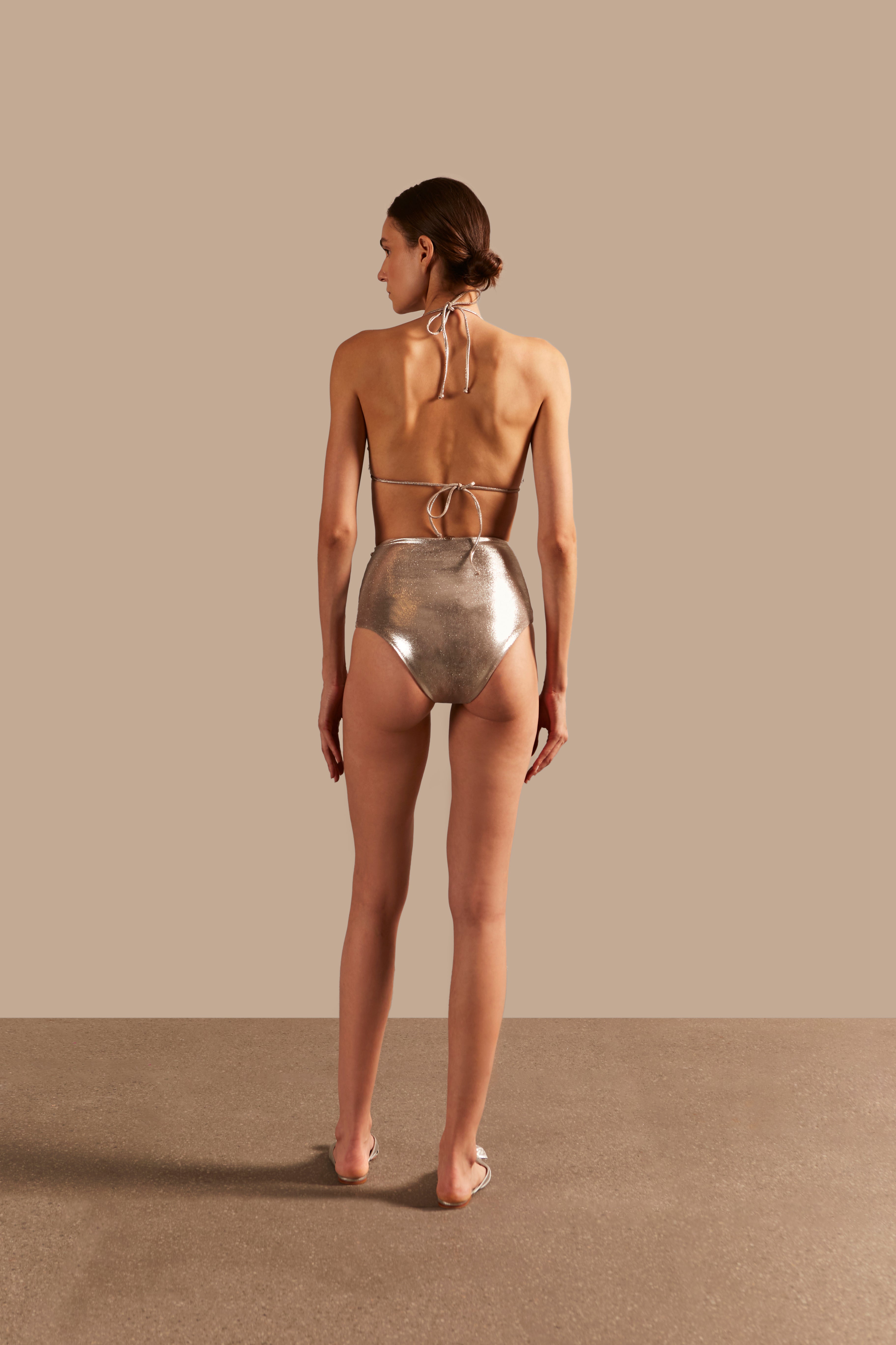 Model wearing the Oysters Solid Silver Lurex High-Waisted Bikini With Pearls showcasing the back of it's redesigned version, on stretchy fabric.