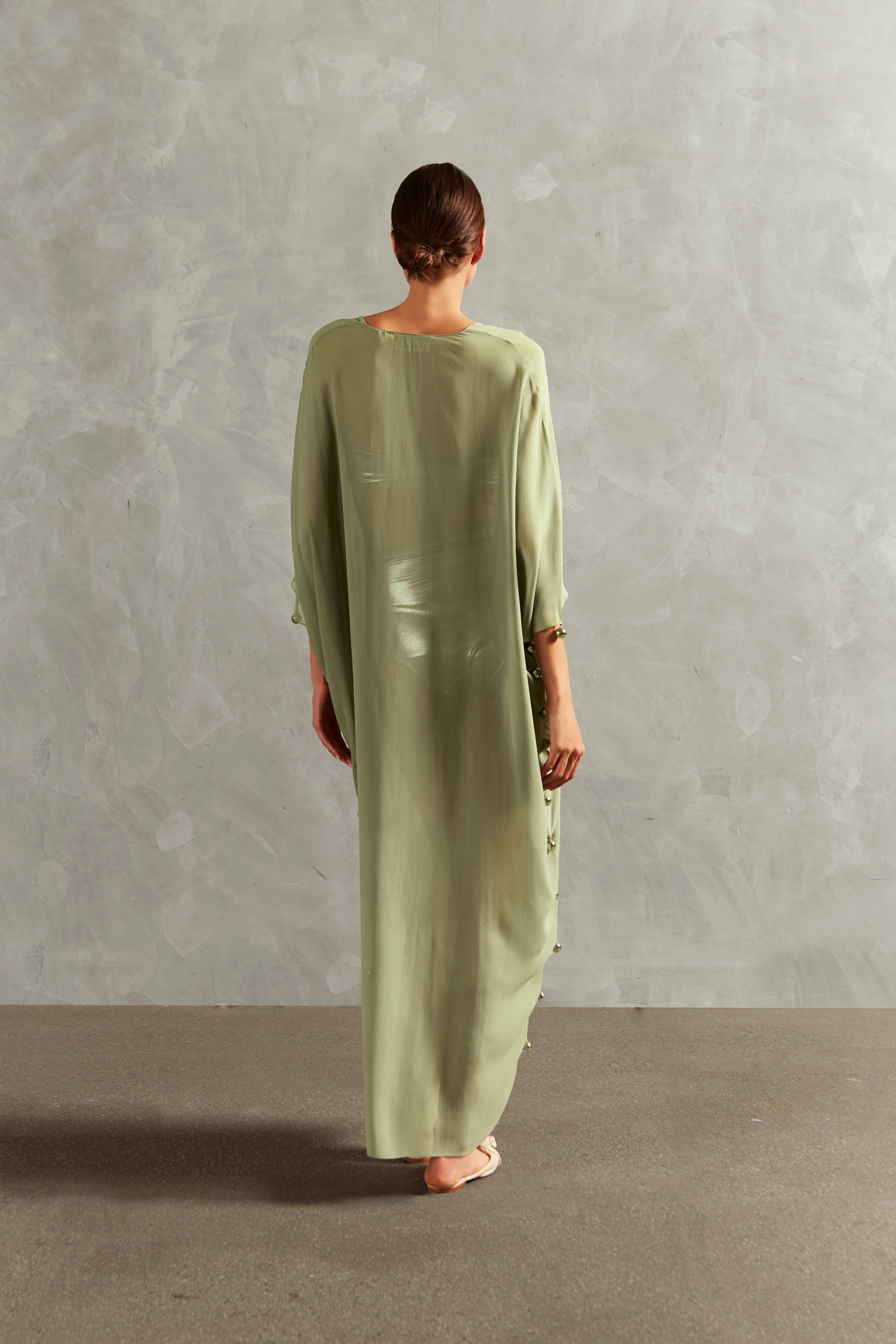 Model wearing the Oysters Solid Long Kaftan With Pearls Back showcasing its sophisticated Green print with Pearls Applications on 100% viscose fabric, styled for a resortwear look.