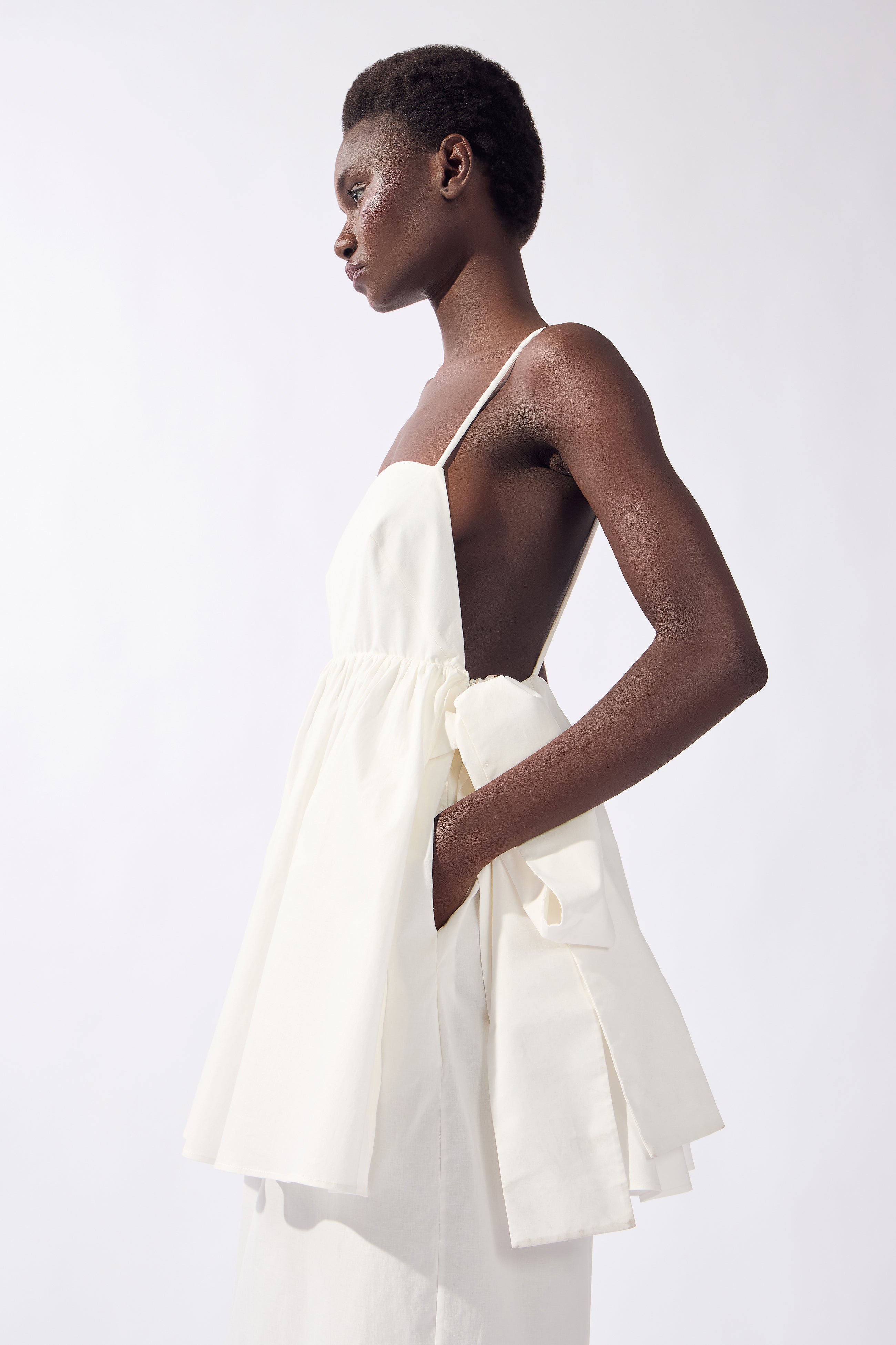 Model wearing the Peplum Maxi Dress detail color off white, made from 98% cotton 2% elastane, styled for resort look 