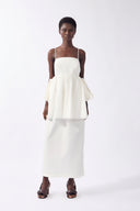 Model wearing the Peplum Maxi Dress front color off white, made from 98% cotton 2% elastane, styled for resort look 