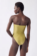 Model wearing the Plunge Swimsuit back, color pistachio made from 85% polyamide 15% elastane, styled for a beachwear look