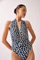 Model wearing the Pois Halterneck Swimsuit navy front from the HS25 with 82% Polyamide 18% Elastane styled for a beach look.   