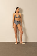 Model wearing the Pois High-Waisted Triangle Bikini pose styled for a beach look