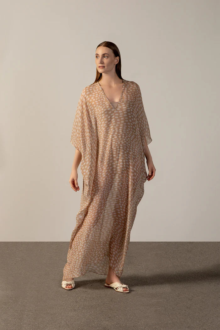 Model wearing the Pois Long Kaftan front color beige, made from 100% silk, styled for a resort look