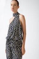 Model wearing the Pois One-Shoulder High-Neck Jumpsuit navy detail from the HS25 with 100% viscose styled for a drinks at sunset look.    