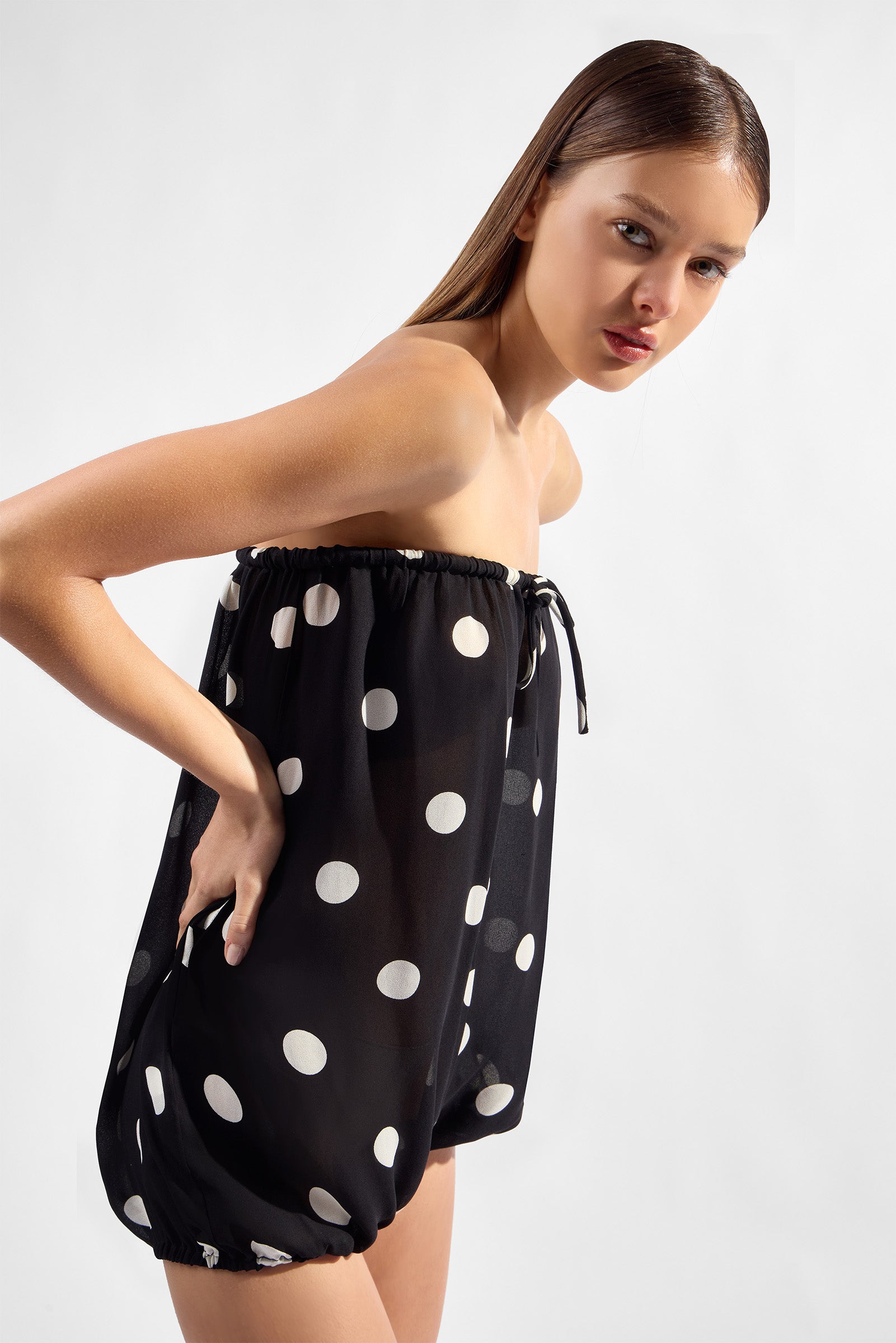 Model wearing the Polka Dots Balone Romper detail color black, made with 100% viscose fabric, styled for resortwear look 