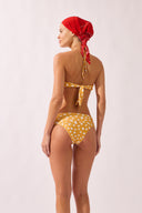 Model wearing the Polka Dots Bandeau Bikini back color cashew yellow, made from 85% polyamide 15% elastane, styled for a beachwear look
