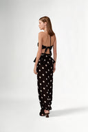Model wearing the Polka Dots Bandeau Top  front color black, made with 100% viscose fabric, styled for resortwear look 